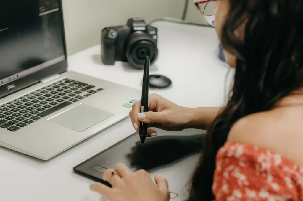 Person creating digital images on a laptop and phone