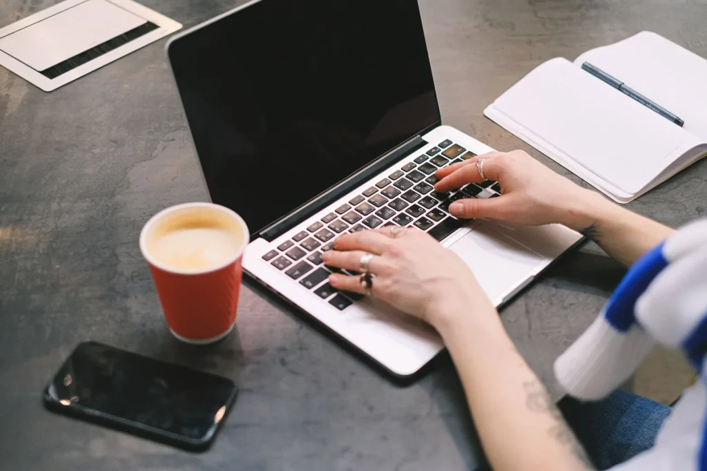 Freelancer working on a laptop at a home desk, the kind of person weighing a $100 ChatGPT Pro plan for a dot