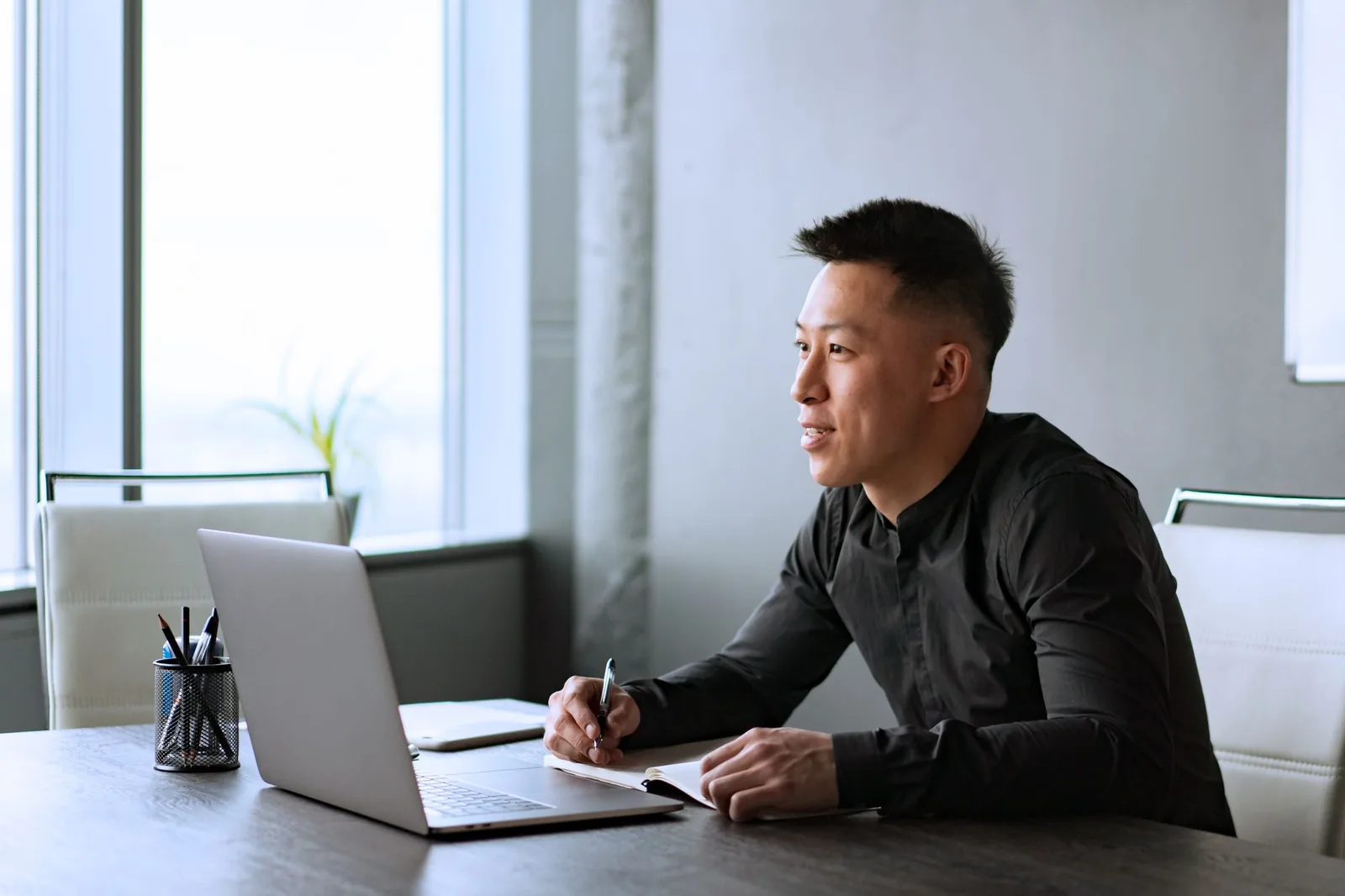 Person at a desk weighing which Claude subscription plan to pay for