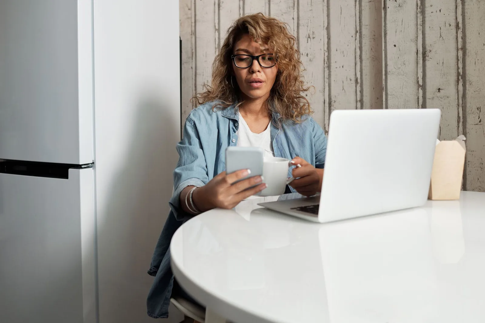 Person comparing free AI tools on a laptop at a kitchen table